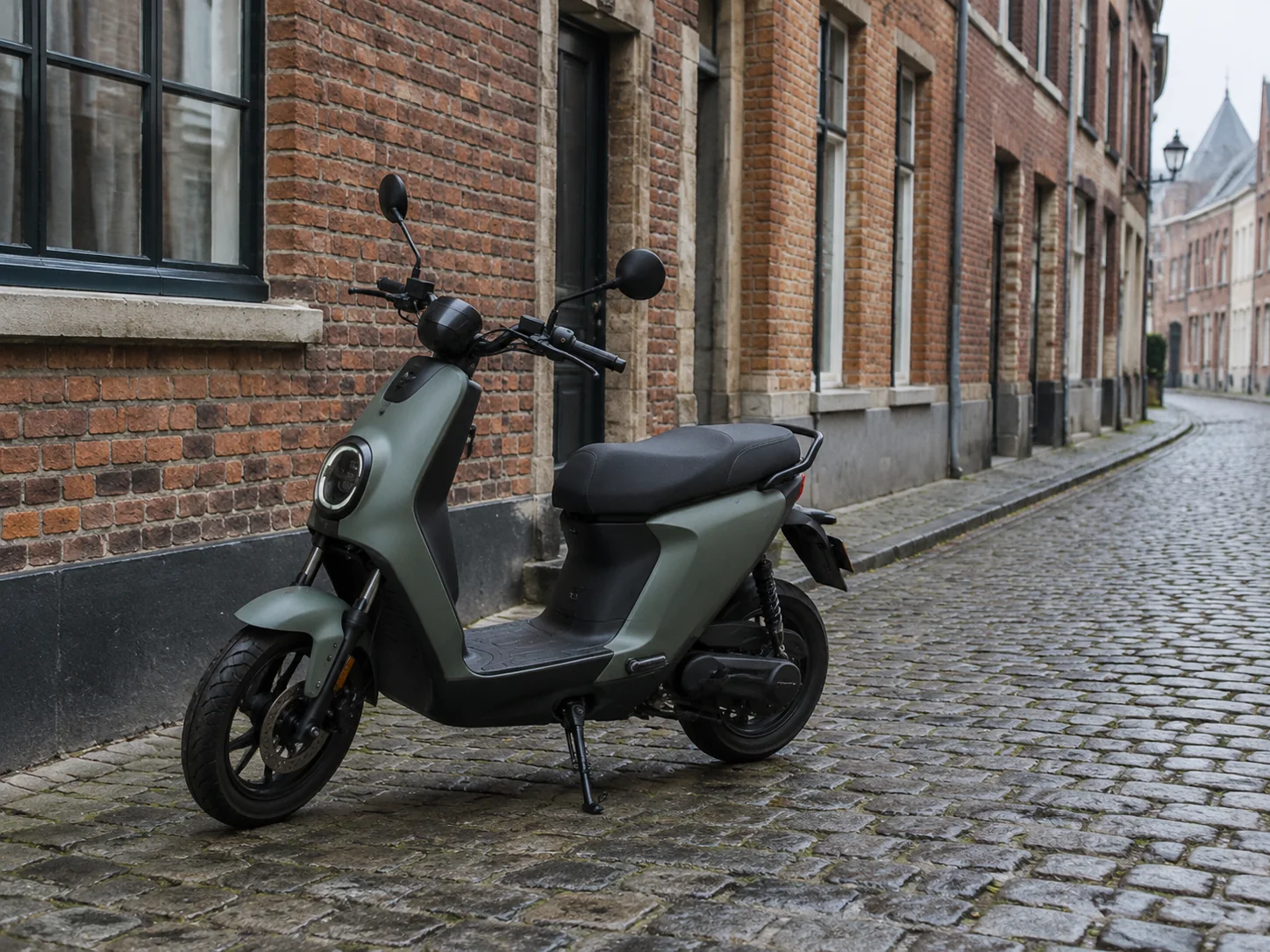 An L1e electric moped parked on a cobbled street